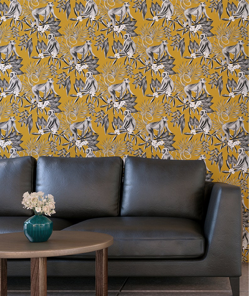May include: A black leather sofa with a yellow and white wallpaper featuring a repeating pattern of monkeys and tropical leaves.