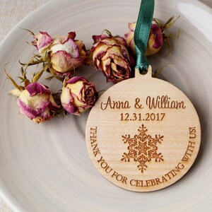May include: A round wooden ornament with a snowflake design and the text "Anna & William 12.31.2017 Thank You For Celebrating With Us!"