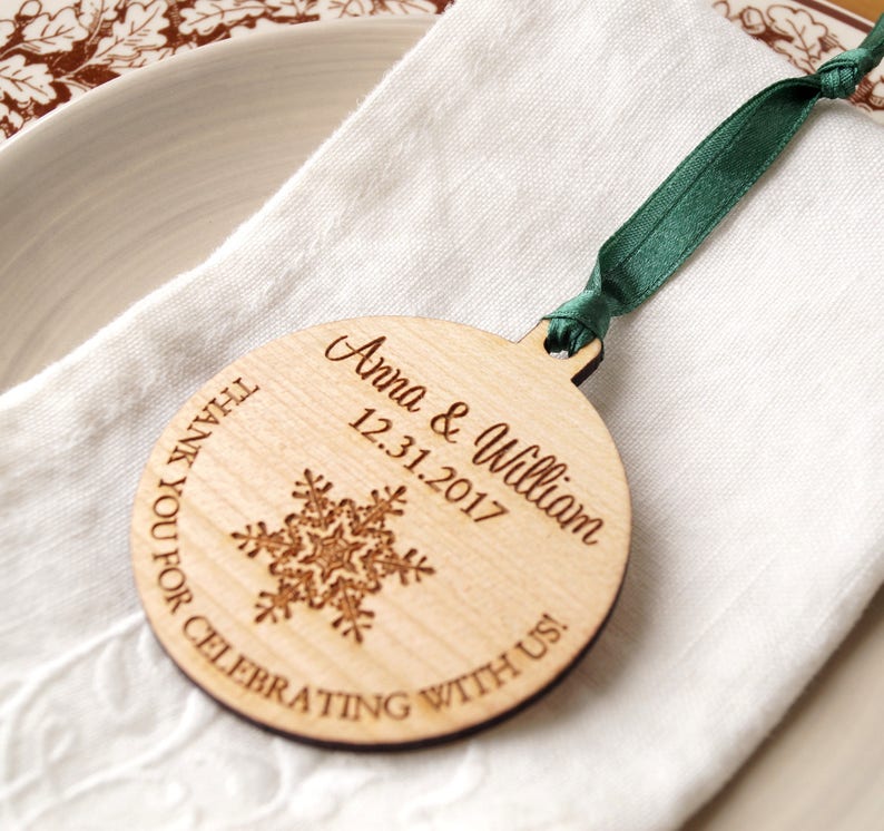 May include: A wooden ornament with a snowflake design and the text "Thank you for celebrating with us! Anna & William 12.31.2017" engraved on it.