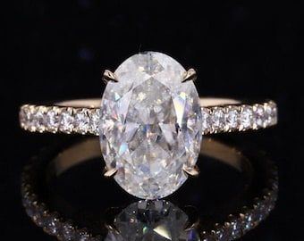 May include: A gold engagement ring with a large oval-shaped diamond and a band of smaller diamonds.