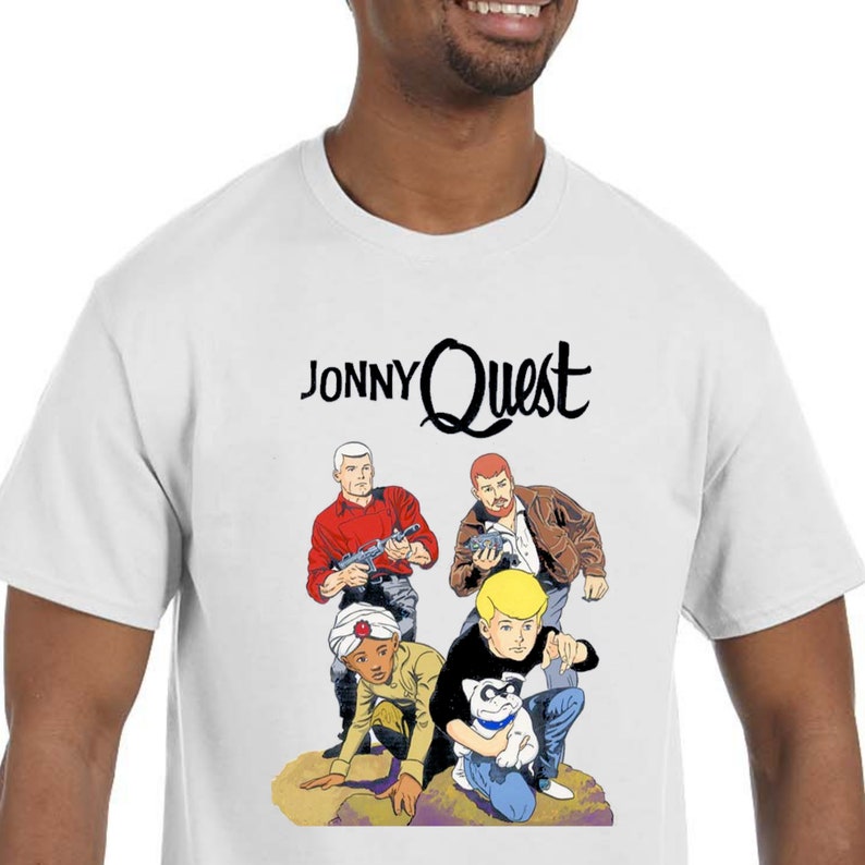 May include: White t-shirt with a cartoon image of Jonny Quest and his friends. The text "Jonny Quest" is printed in black above the image.