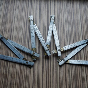 Metallischer Zollstock, ein Meter langer Messstab, Tischlerwerkzeug, Werkstattdekor oder rustikales Dekor