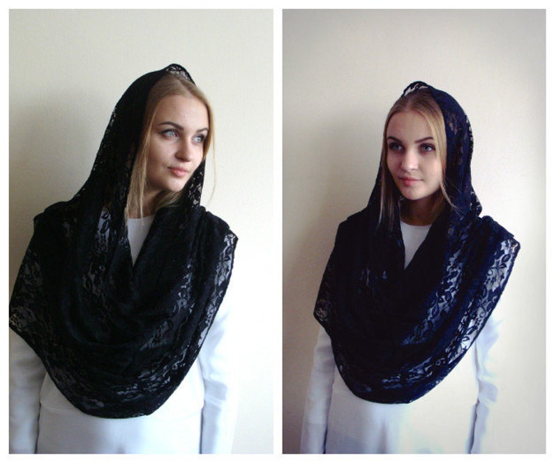 May include: A black lace shawl with a hood. The shawl is draped over a person's shoulders and head.