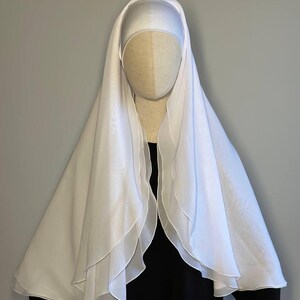 Op de afbeelding: Witte chiffon hijab met een gelaagd ontwerp. De hijab is gedrapeerd over de kop en schouders van een mannequin.