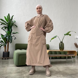 Conjunto de abaya beige impermeable, pantalones tipo harén y vestido hijab con capucha