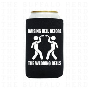 May include: Black can cooler with white text that reads "RAISING HELL BEFORE THE WEDDING BELLS." The design features two stick figures toasting with drinks. The can cooler is wrapped around a silver can.