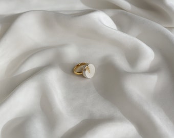 anillo de hormigón blanco con patrón dorado