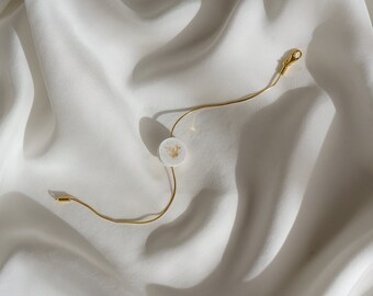 pulsera de hormigón blanco con patrón dorado