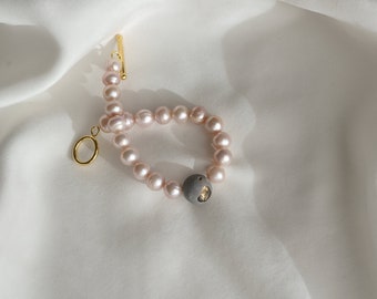 pulsera de declaración de perla rosada con hormigón gris y oro