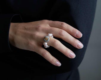 Anillo llamativo de perlas rosadas con hormigón y oro