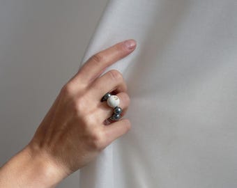 Anillo llamativo de perla negra con hormigón blanco y oro