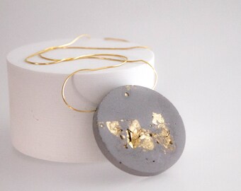 collar de declaración de hormigón gris y oro