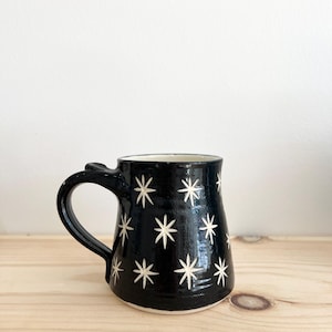 May include: Black ceramic mug with a white star pattern.