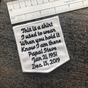 May include: White fabric patch with black embroidered text that reads "This is a shirt I used to wear When you hold it Know I am there Papal Steve Jan 21, 1951 Dec. 15, 2019".