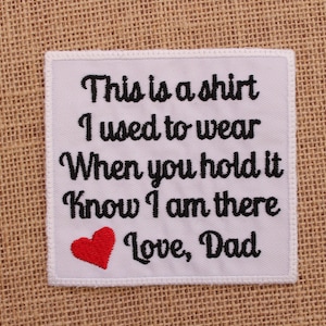 May include: White fabric patch with black embroidered text that reads "This is a shirt I used to wear When you hold it Know I am there Love, Dad". A red heart is embroidered below the text.