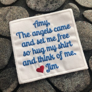 May include: White fabric patch with blue embroidered text that reads "Amy, The angels came and set me free so hug my shirt and think of me. Jim" with a red heart.