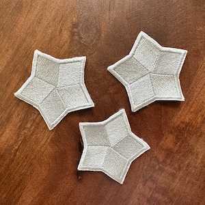 May include: Three white star-shaped fabric patches with a checkered pattern.