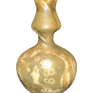 May include: An Art Nouveau style vase with a bulbous body and a tulip-shaped top. The vase is primarily gold with a cream-colored portrait of a woman on the front. The design features flowing lines and floral motifs, typical of the era.