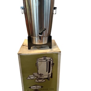 May include: A vintage West Bend 30-cup automatic party perk coffee maker in stainless steel. The coffee maker is in its original box with a green and white design. The box features a drawing of the coffee maker and four cups.