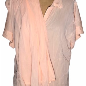 May include: A peach-colored button-down shirt with short sleeves. The shirt is made of a lightweight fabric and has a relaxed fit.