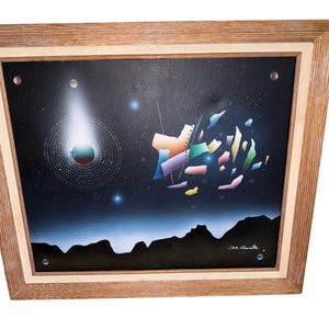 May include: Abstract space-themed painting in a wooden frame. The artwork features a dark blue background with a comet, planets, and geometric shapes in various colors. The painting is signed in the lower right corner.