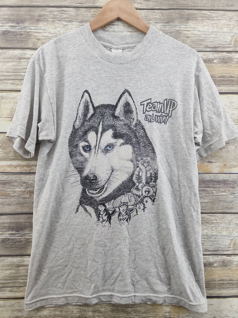 May include: Gray t-shirt with a graphic of a husky dog and the text "Team Up and Win!"