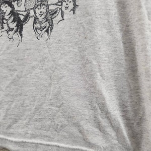 May include: A gray t-shirt with a black and white illustration of a team of sled dogs pulling a sled.