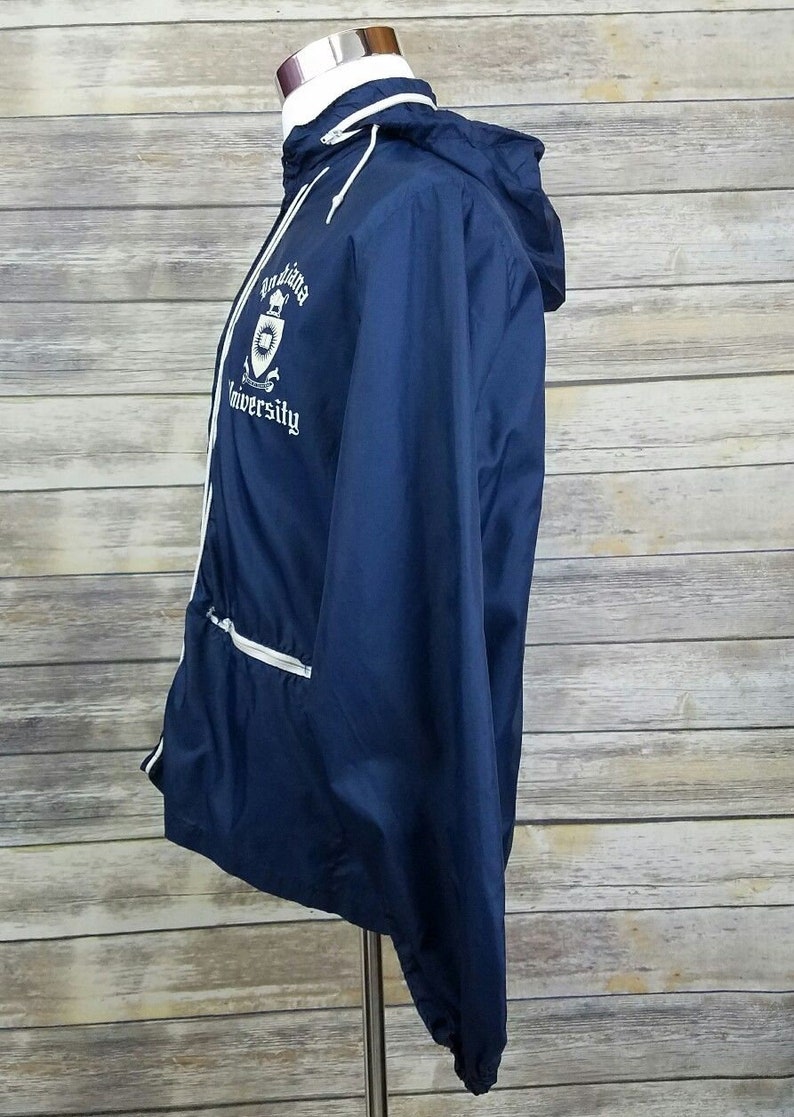 May include: A navy blue windbreaker jacket with white piping and a white embroidered logo that says "Louisiana University".