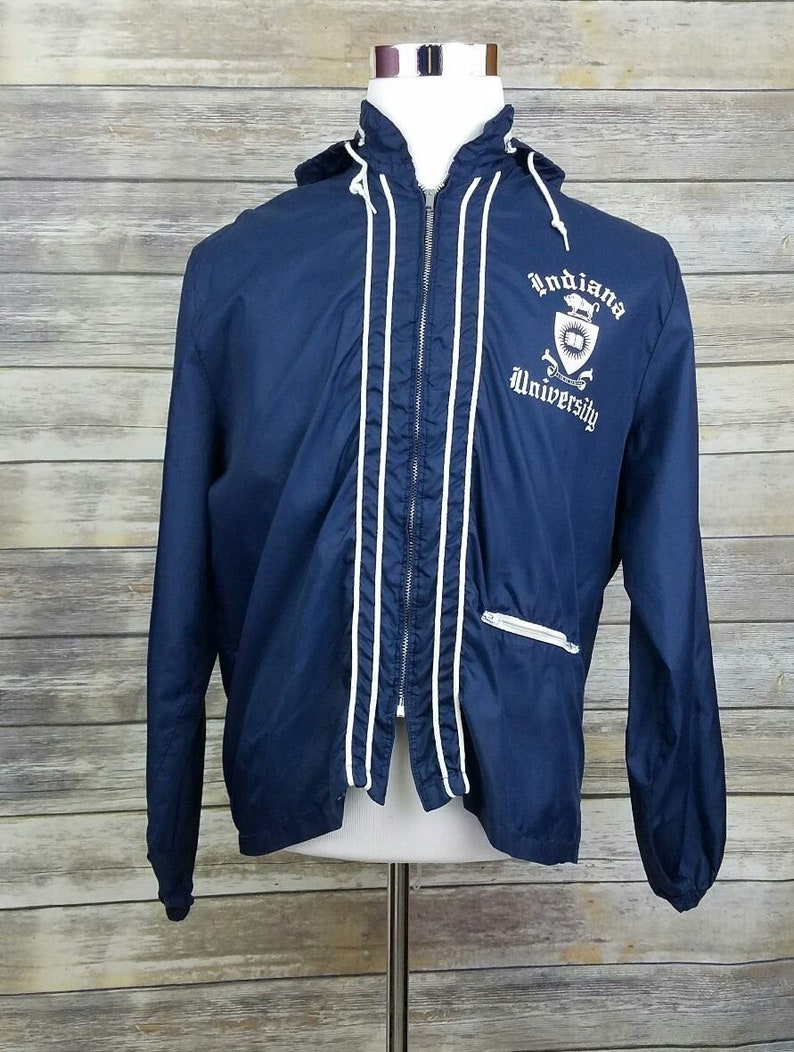 May include: A navy blue hooded jacket with white piping and a white embroidered logo that says "Indiana University".