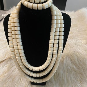 May include: A set of three white beaded necklaces with a matching bracelet. The beads are round and have a smooth, polished finish.