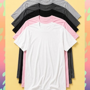 May include: Five crew neck t-shirts in a stack, in shades of grey, black, pink and white. The shirts are displayed on a yellow background with a colourful border. The text "EMPURE ROUGH" is visible at the bottom of the image.