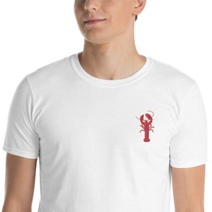 May include: White t-shirt with a red lobster graphic on the front.