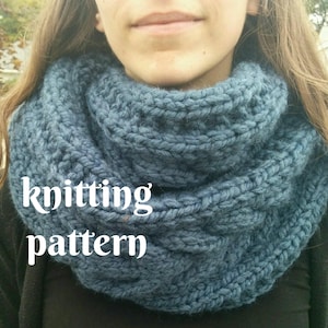May include: A blue knitted infinity scarf with a cable knit pattern. The scarf is worn by a person, but the person's face is not visible. The text "knitting pattern" is visible in the image.
