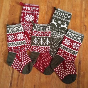 Peut inclure: Six bas de Noël personnalisés avec les noms MOM, DAD, MORGAN, JACOB et MAGGIE. Tricotés en rouge, blanc et vert, ils présentent des motifs de flocons de neige et d'arbres. Chaque bas a une boucle pour être accroché.