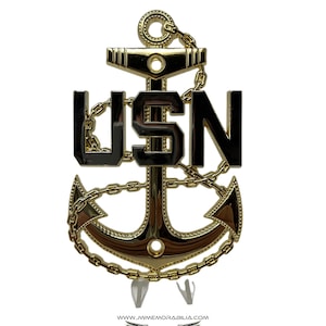 May include: Gold-colored metal US Navy anchor with a chain and the letters USN in black.