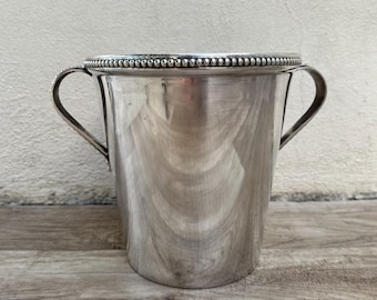 May include: Silver ice bucket with two handles and a beaded rim.