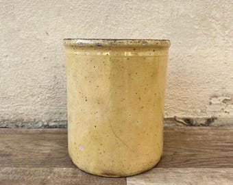 May include: A yellow ceramic jar with a speckled glaze. The jar has a rounded shape and a slightly flared lip.
