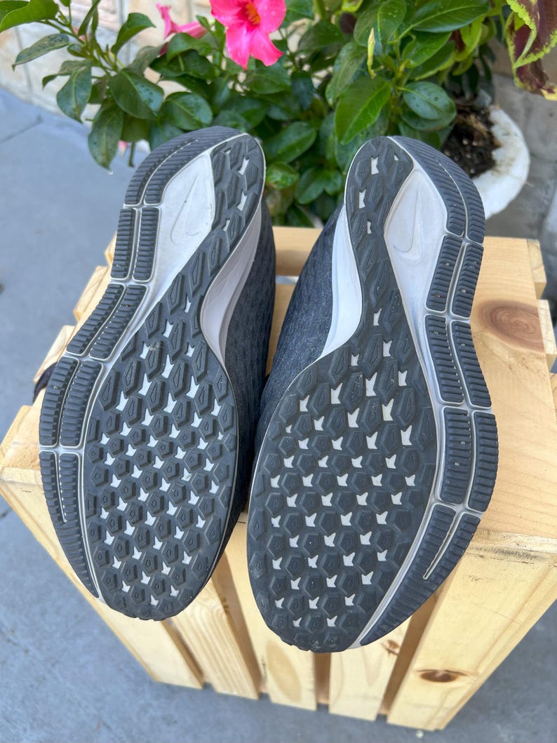 K&ouml;nnte beinhalten: Schwarze Laufschuhe mit einem wei&szlig;en Swoosh-Logo und einem schwarzen und wei&szlig;en Profil.