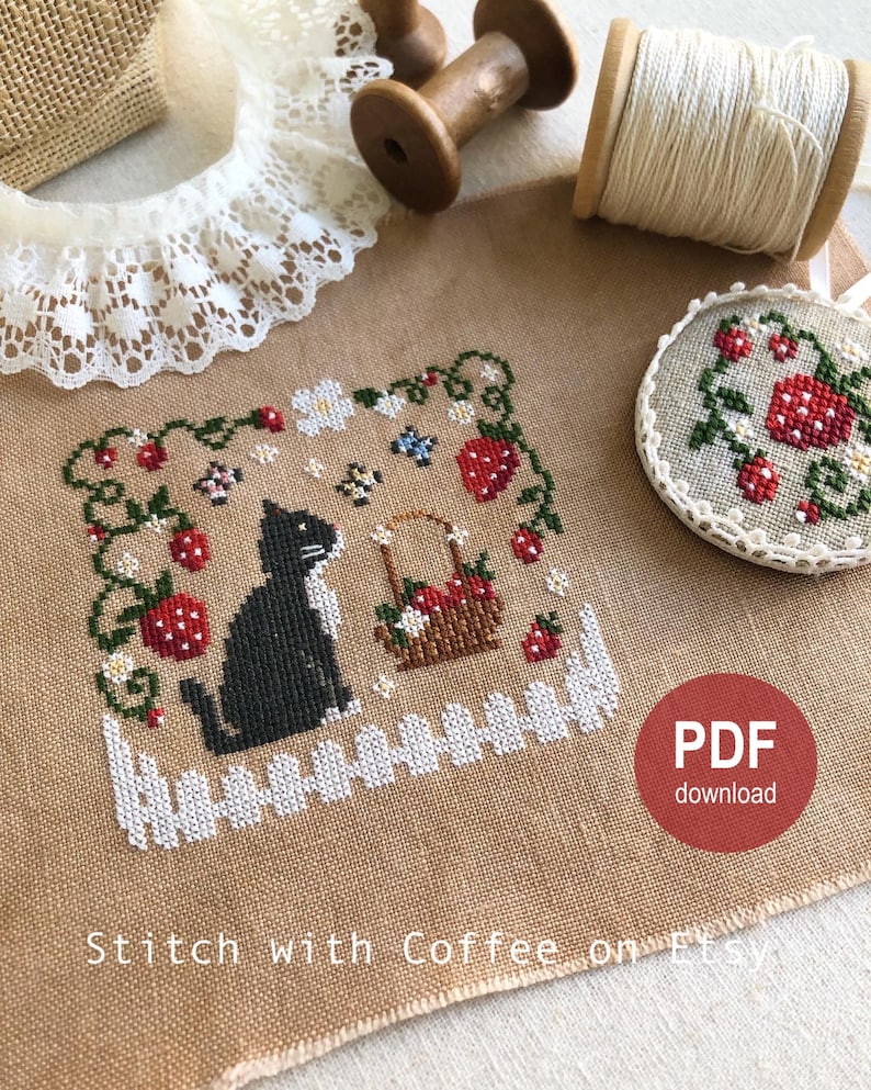 May include: Cross stitch pattern featuring a black cat sitting in a garden with strawberries, flowers, and a basket of strawberries. The pattern is on a beige fabric with the text "PDF download" in the bottom right corner.