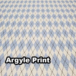 May include: A close-up of a blue and white argyle print fabric. The fabric has a textured surface and a subtle sheen.