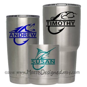May include: Three stainless steel tumblers with personalized fishing-themed designs. The tumblers feature a blue fish with a hook, a black fish with a hook, and a teal marlin with a hook. The names "Andrew", "Timothy", and "Susan" are printed on the tumblers.