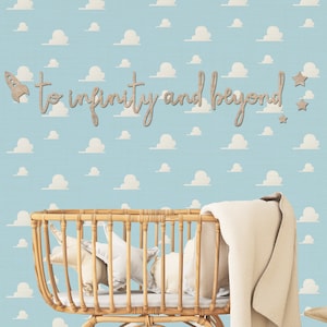 Peut inclure: Un papier peint bleu clair avec un motif r&eacute;p&eacute;titif de nuages blancs. Fix&eacute;e au mur, une inscription en bois d&eacute;coup&eacute; porte le texte to infinity and beyond, accompagn&eacute;e d'une petite fus&eacute;e et de trois &eacute;toiles dans une finition brun clair.