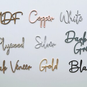 Peut inclure: Un ensemble de neuf &eacute;chantillons de bois avec leurs noms &eacute;crits en cursive sur chaque pi&egrave;ce. Les &eacute;chantillons sont dans les couleurs suivantes : MDF (brun), Cuivre (or rose), Blanc (blanc), Contreplaqu&eacute; (bois naturel), Argent (argent), Gris fonc&eacute; (gris), Placage de ch&ecirc;ne (bois naturel), Or (or) et Noir (noir).