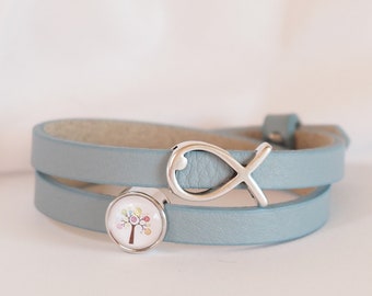 May include: A light blue leather wrap bracelet with a silver infinity symbol charm and a round, white cabochon with a colorful tree design.