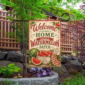 May include: A rectangular garden flag featuring a cream-colored background with the text Welcome to our Home Sweet Watermelon Patch. The design includes illustrations of whole and sliced watermelons, a bowl, and a red checkered cloth napkin.