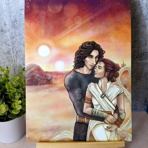 May include: A painting of a couple embracing in a desert landscape. The man has dark hair and is wearing a black shirt. The woman has brown hair and is wearing a white dress. The background is a sunset with two suns and a starry sky.
