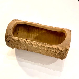 May include: A brown ceramic planter shaped like a log with a rough bark texture.
