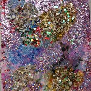 Könnte beinhalten: Abstraktes Kunstwerk mit einer Mischung aus Texturen und Farben. Das Kunstwerk zeigt Bereiche in Blau, Lila und Gold, mit eingebettetem Glitzer, kleinen Muschelsplittern und bunten Konfetti. Der Gesamteffekt ist eine schimmernde, strukturierte Oberfläche.