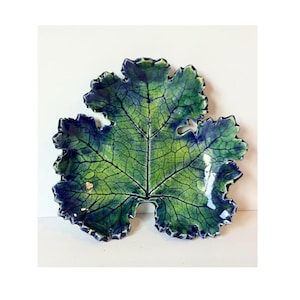 May include: A ceramic dish shaped like a large leaf with a glossy finish. The surface features a vibrant gradient of lime green in the center transitioning to deep indigo blue at the edges, with dark, intricate veins etched across the entire surface.