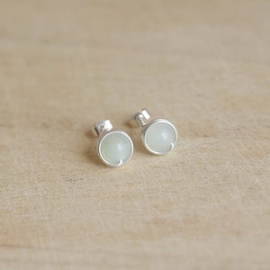 May include: A pair of silver stud earrings with white round stones.